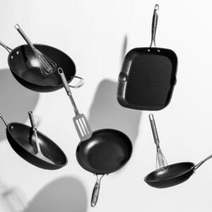 Interesting shot of trendy black kitchen utensils dancing on white background